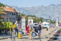 Tourists with suitcases, backpack and bags walk along the yachts and motorboats moored at the pier